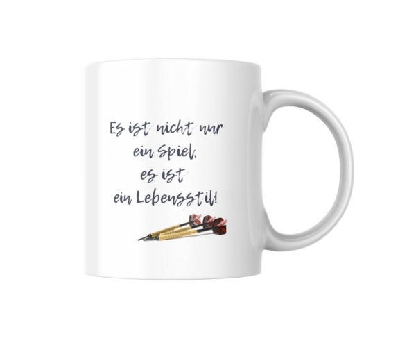 Weiße Keramiktasse mit Dart-Motiv. Die Tasse trägt den motivierenden Spruch „Es ist nicht nur ein Spiel, es ist ein Lebensstil!“ in stilvoller Schrift. Unter dem Text sind drei goldene Dartpfeile abgebildet. Perfekt als Geschenk für Dartspieler und Fans d
